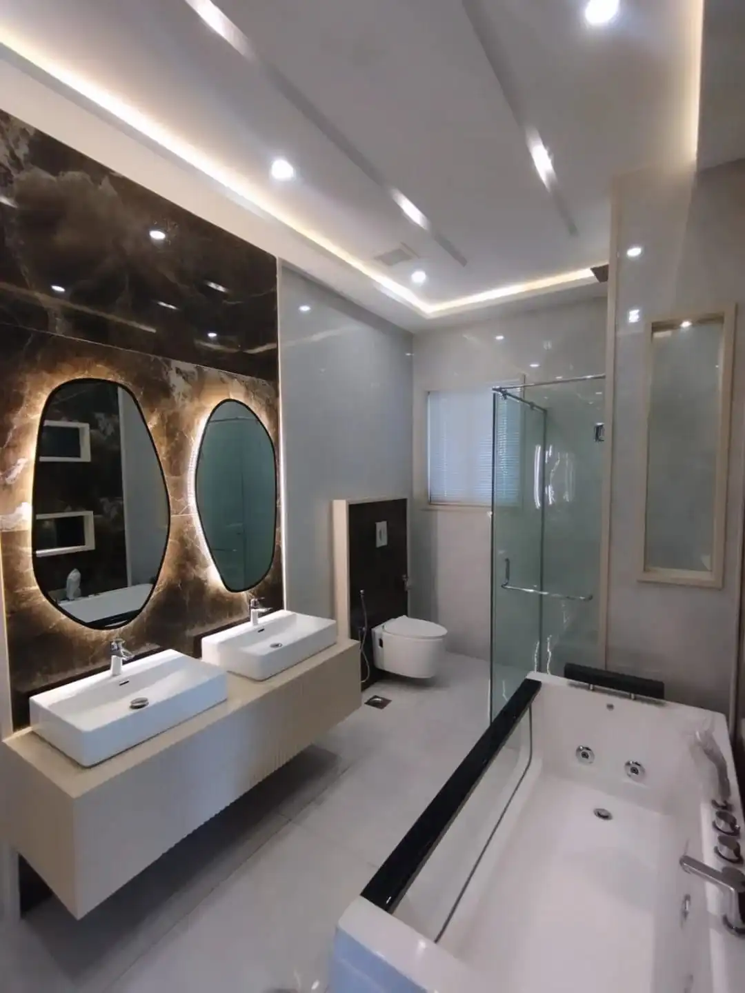 Luxury master bathroom with double vanity jacuzzi tub glass shower and marble wall in 1 Kanal house Lake City