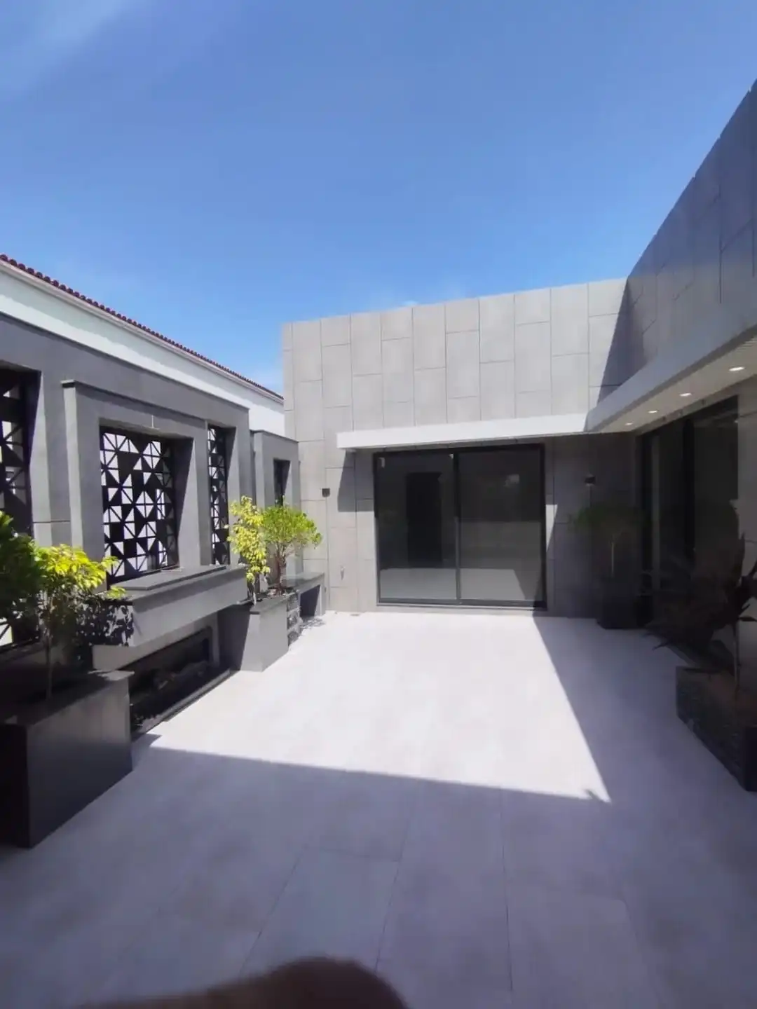 1 Kanal luxury house courtyard with modern tiles and sliding glass door in Lake City M3 Lahore