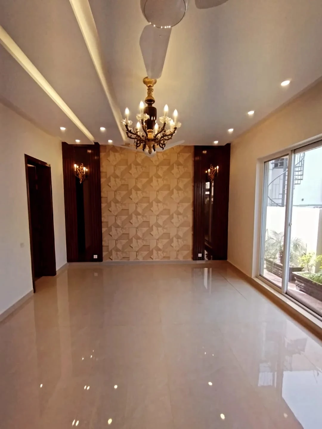 Spacious TV lounge with textured stone feature wall, chandelier and marble flooring in 1 Kanal house Block M2 Lake City