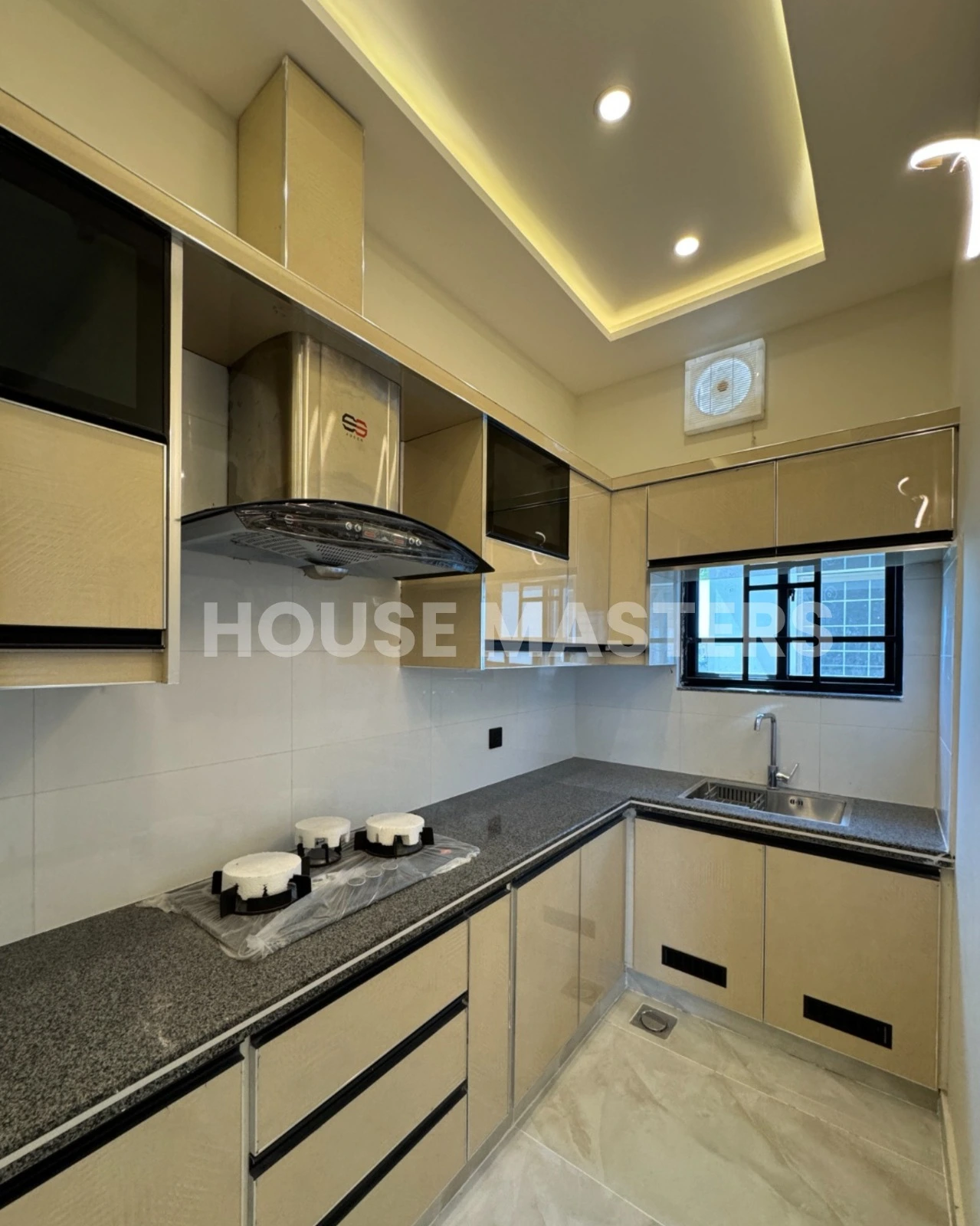 Elegant Kitchen Design – 5 Marla Luxury Home Contemporary kitchen with beige cabinets, black countertops, and integrated appliances in premium 5 Marla residence, Bahria Orchard.