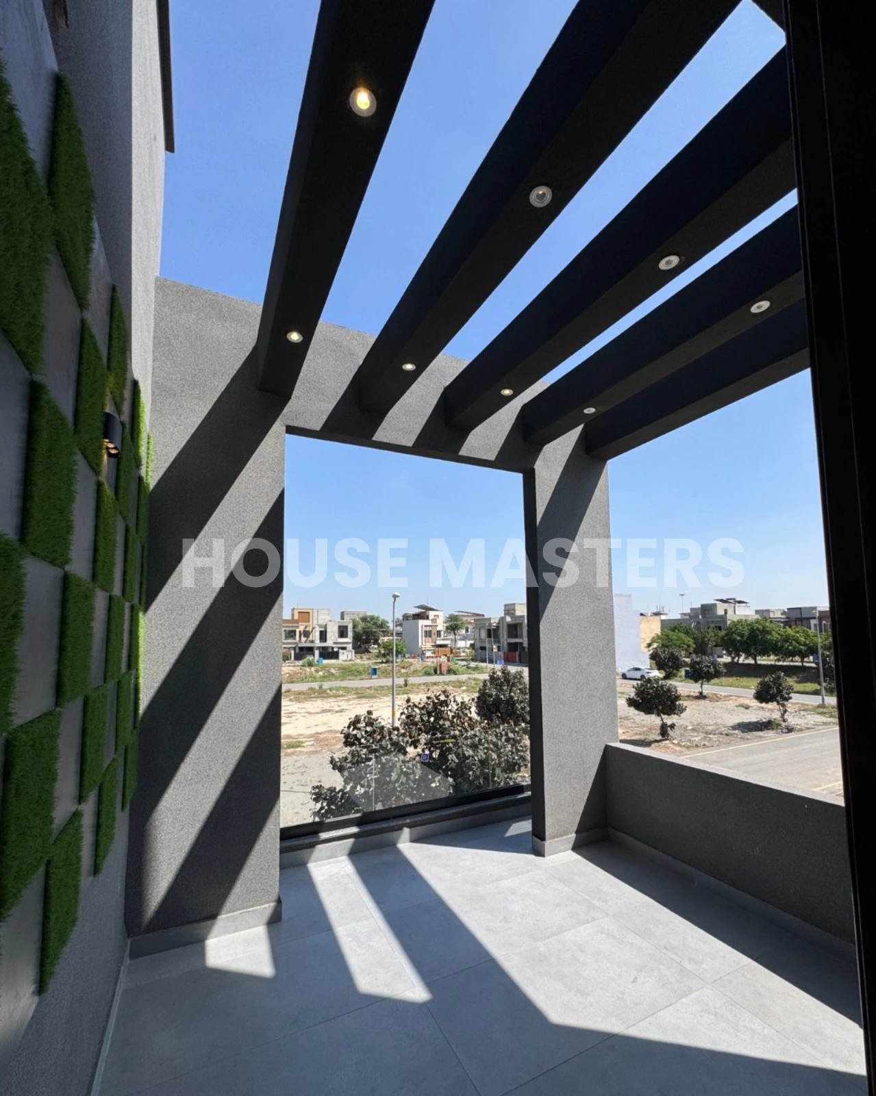 Stylish Balcony – 5 Marla House, Bahria Orchard Modern balcony with black beams, grey flooring, and partial outdoor view in 5 Marla premium home, Bahria Orchard.