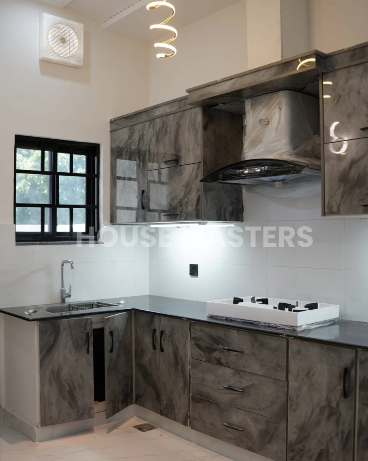 Modern Kitchen – 5 Marla House, Bahria Orchard High-end kitchen with dark marble cabinets, black countertops, and modern appliances in 5 Marla luxury home, Bahria Orchard.