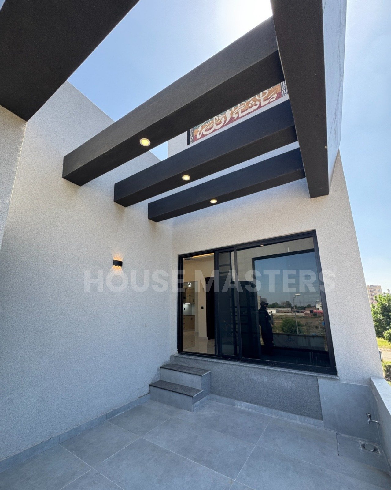 Stylish Balcony – 5 Marla House, Bahria Orchard Modern balcony with black beams, grey flooring, and partial outdoor view in 5 Marla premium home, Bahria Orchard.