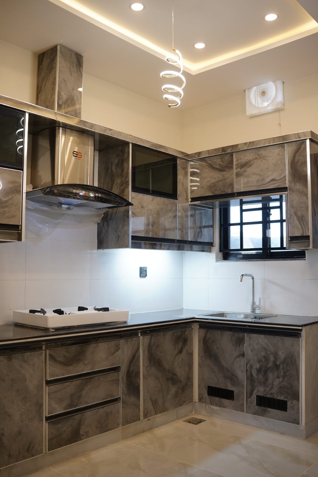 Elegant Kitchen Design – 5 Marla Luxury Home Contemporary kitchen with beige cabinets, black countertops, and integrated appliances in premium 5 Marla residence, Bahria Orchard.