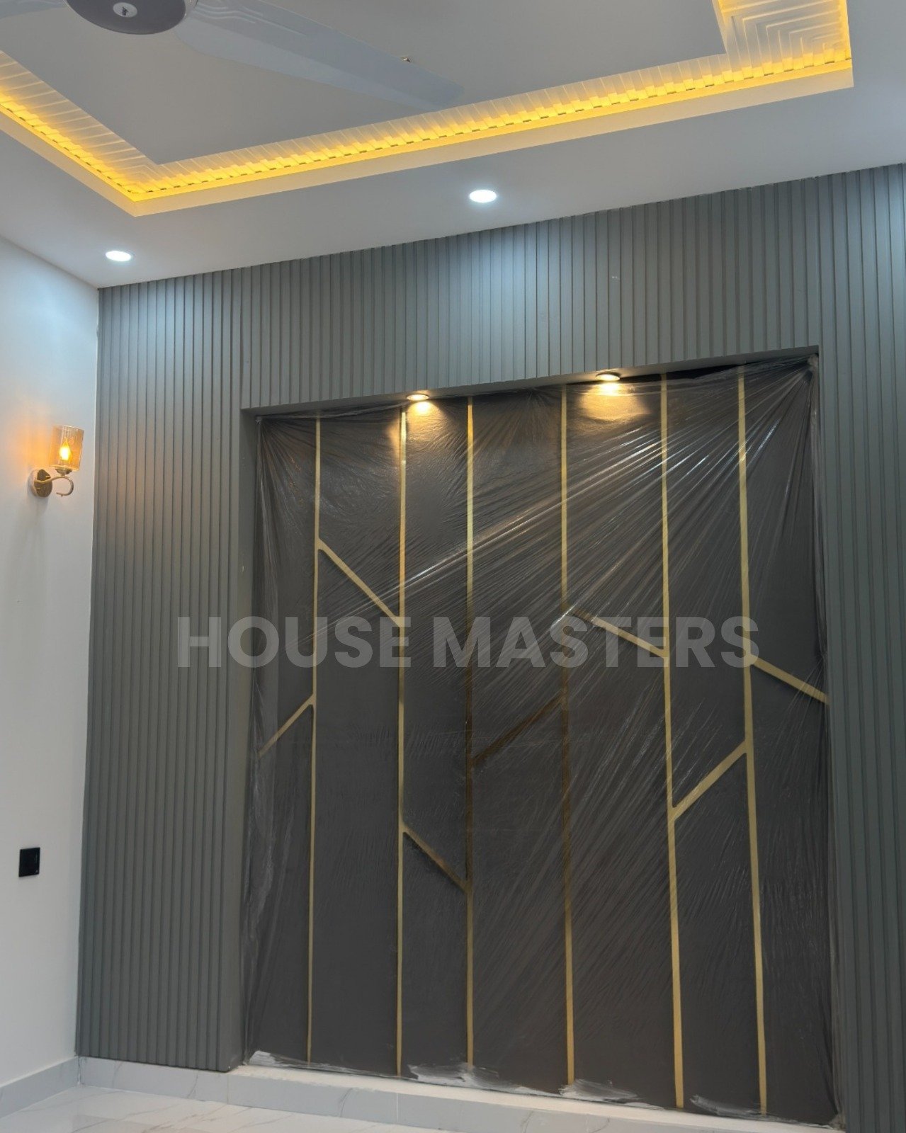 Contemporary Feature Wall – 5 Marla Luxury Home Modern interior feature wall with grey panels, gold accents, and built-in spotlights in 5 Marla luxury home, Bahria Orchard