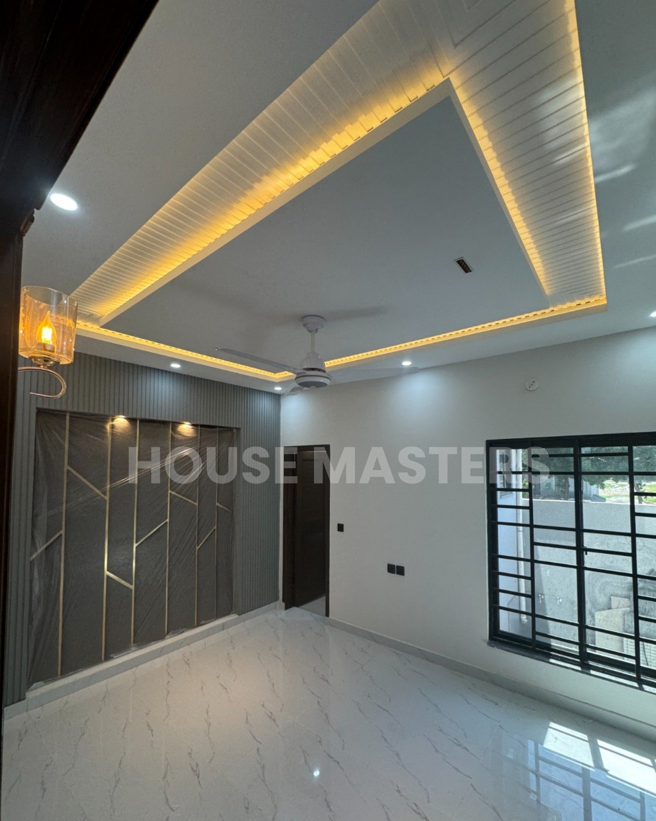 Luxury Living Room Design – Bahria Orchard Lahore Spacious living area with modern ceiling design, ambient lighting, and large windows in 5 Marla house, Bahria Orchard, Lahore.